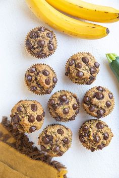 banana and chocolate chip muffins on a white surface next to some zucchini