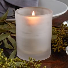 a white candle sitting on top of a wooden table