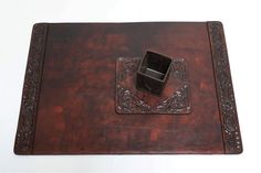 an old wooden box with a ring on it's lid sitting on a white surface