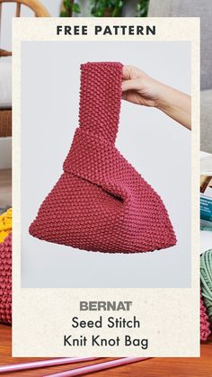 a knitted bean bag sitting on top of a wooden table next to knitting needles