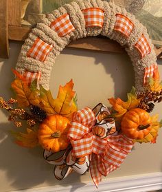 an orange and white wreath with pumpkins on it