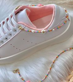 a white sneaker with pink and yellow beads