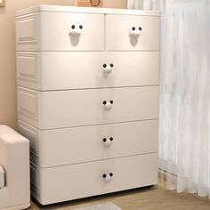 a white dresser with four drawers in a room