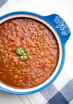 a bowl of beans and jalapeno soup on a checkered table cloth