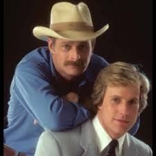 two men in suits and hats are posing for a photo together with their arms around each other