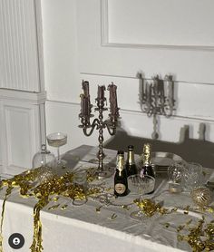 a table topped with bottles of champagne and confetti on top of a table