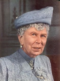 an older woman wearing a blue hat and dress