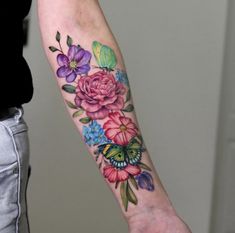 a woman's arm with flowers and butterflies on it