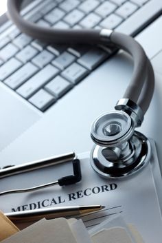 a stethoscope sitting on top of a medical record next to a keyboard