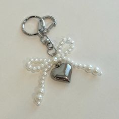 a heart shaped keychain with pearls attached to it