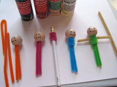 some crafting supplies are arranged on a table with pens and glues next to them