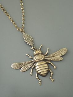 a gold necklace with a bee on it