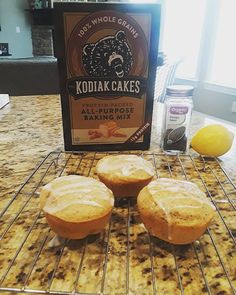 three muffins sitting on top of a cooling rack next to a package of kodiak cakes