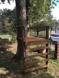 a wooden tree stand next to a tree