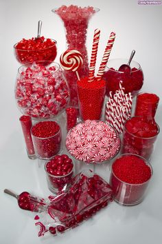 a table topped with lots of candy and candies on top of glass vases