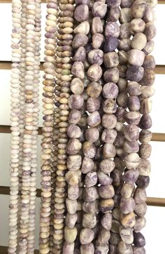 several different beads hanging from a wooden rack