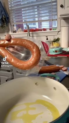 a hot dog is being cooked in a frying pan on the kitchen counter top