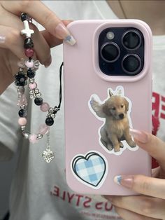 a person holding a pink phone case with a dog sticker on the front and side