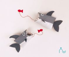 two paper shark puppets with red hearts attached to them