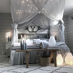 a bed room with a neatly made bed and some lights on the wall above it