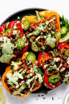 stuffed bell peppers topped with green sauce and sliced jalapenos