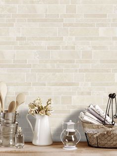 kitchen utensils on counter with white brick wall