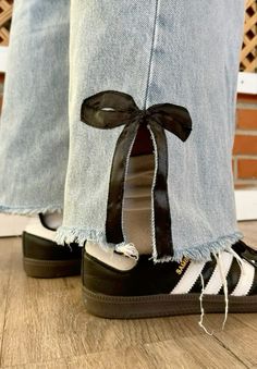 a pair of legs with black and white shoes tied to the bottom of each shoe