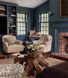 a living room filled with furniture and a fire place in front of a fireplace covered in bookshelves