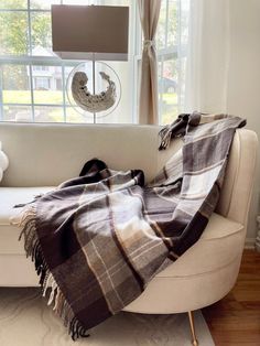 a couch with a blanket on it in front of a window