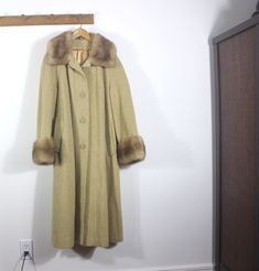 "1960's Authentic Vintage wool and camel hair coat with mink collar and cuffs. Fully lined, button front, raglan sleeves, hip pockets. This is in excellent gently worn vintage condition with some stains and wear on the lining inside. No external damage detected. I would call this a small to medium with ample chest room. 94% wool 6% camel Shoulder to shoulder (approximate since there are no seems) 18\" Pit to pit 23\" Back of neck to hem 42\" Arm pit to sleeve cuff 16\" Top of pockets across (hip Retro Winter Outerwear With Button Cuffs, Vintage Winter Outerwear With Button Cuffs, Vintage Fitted Wool Coat For Winter, Vintage Fur Coat For Winter Formal Occasions, Vintage Fur Coat For Winter Formal, Vintage Fur Coat For Formal Winter Occasions, Vintage Winter Fur Coat For Formal Occasions, Formal Vintage Outerwear With Faux Fur Trim, Mid-century Long Sleeve Winter Outerwear