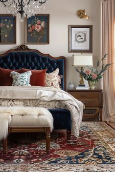 a bedroom with an ornate bed, chandelier and two paintings on the wall