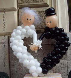 two people made out of balloons in the shape of a heart