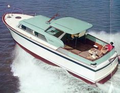 a small boat with two people on the deck in the middle of the ocean water