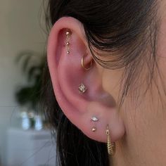 a close up of a person's ear with three different types of piercings