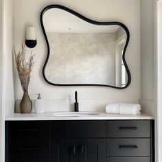 a bathroom vanity with a large mirror above it