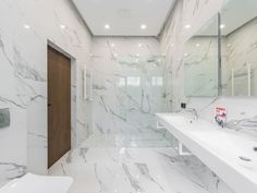 a bathroom with white marble walls and floors