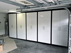 an empty garage with white cabinets and black trim on the doors, carpeted floor