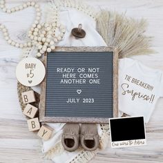 a baby announcement is displayed on top of a wooden table with other items and decorations