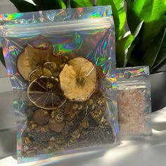 two bags filled with food sitting on top of a table next to a potted plant