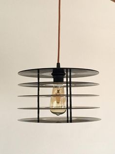 a light that is hanging from a wire on the ceiling with a bulb attached to it