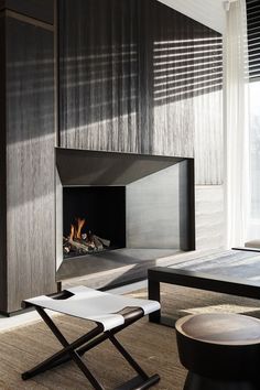 a living room with a fire place next to a table and chair in front of a window