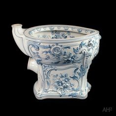 an ornate blue and white bowl with flowers on it's sides, against a black background