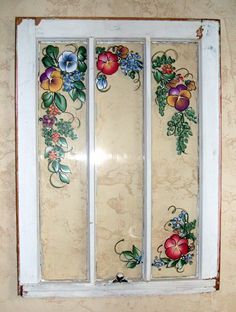 an old window with flowers painted on it