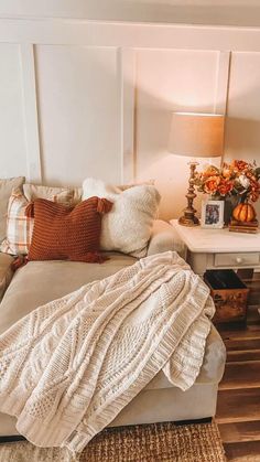 a living room filled with furniture and a blanket on top of a couch next to a table