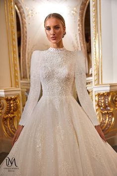 a woman wearing a wedding dress with long sleeves