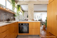 a kitchen with wooden cabinets and white counter tops, along with a black stove top oven