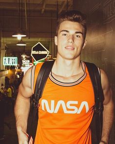 a young man in an orange nasa shirt