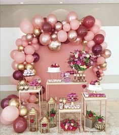 a pink and gold dessert table with balloons