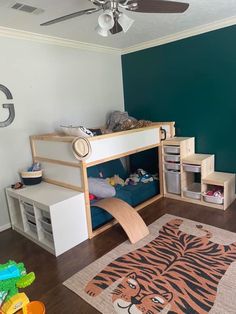 there is a bunk bed with a tiger rug on the floor and other toys in front of it