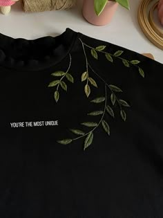 a t - shirt that says you're the most unique with green leaves on it